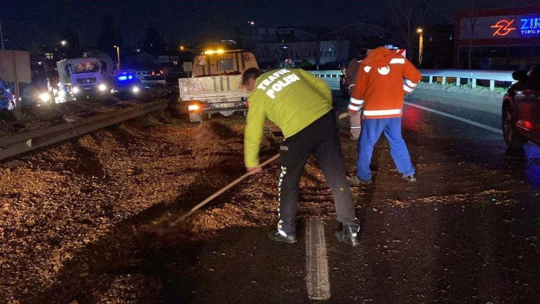 Polis eline aldığı fırçayla devrilen tırdan yola dökülen talaşı temizledi