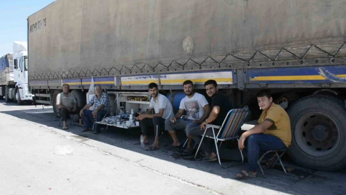 Şırnak'ta tır parkında bekleyen şoförler araçlarının gölgesinde serinliyor