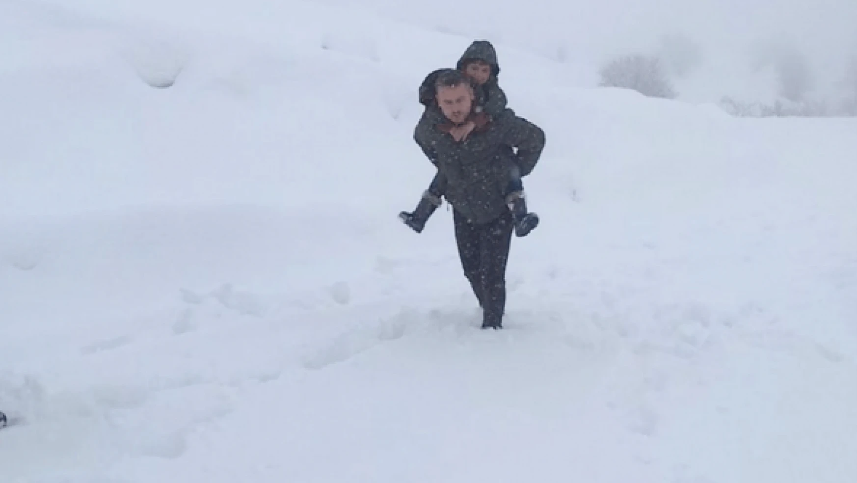 Hakkari'de okul müdürü karda yürüyemeyen öğrenciyi sırtında taşıdı