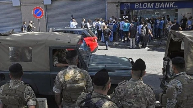 Paralarını çekemeyen göstericiler, bankayı bastı