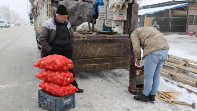 Doğu buz kesti, pazarcılar soğuktan korunmak için soba kurdu