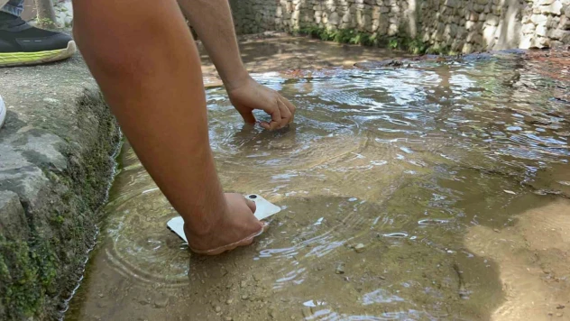 Sıcaklığın 45 dereceyi bulmasıyla telefonlarını suda soğuttular