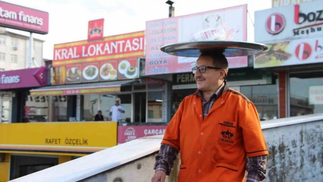 Sipariş verilen yemekleri kafasında taşıdığı tepsi ile götürüyor
