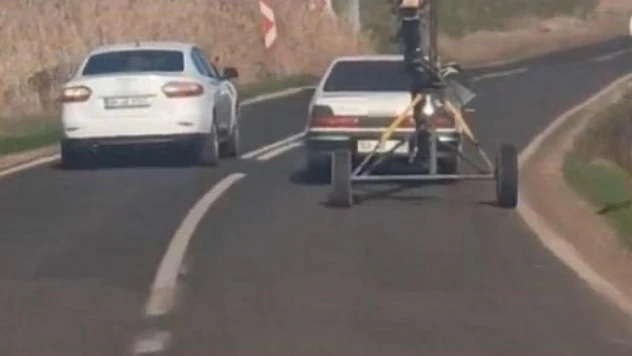 Traktörlerle çekilen helezon makinesini otomobile bağlayarak çekti