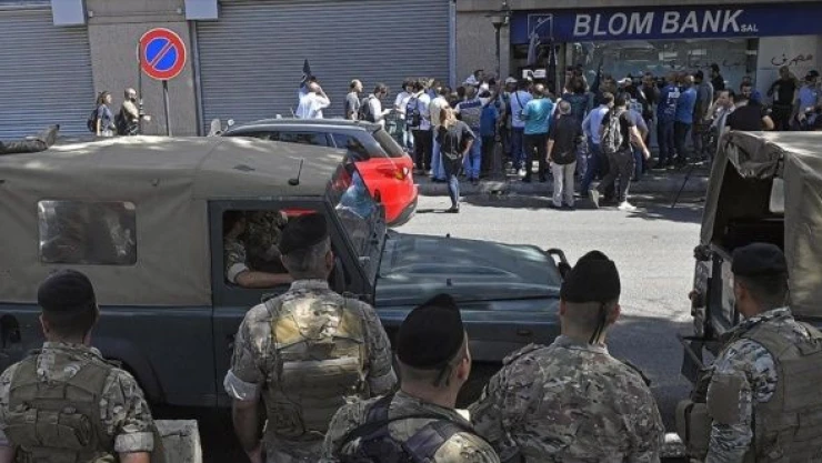 Paralarını çekemeyen göstericiler, bankayı bastı